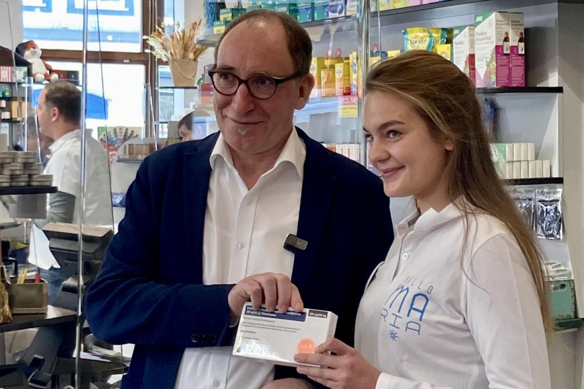Gesundheitsminister Johannes Rauch mit Mag. Mariam Baraka in der Marien Apotheke Wien. Beide halten gemeinsam eine Packung eines PrEP-Medikaments.