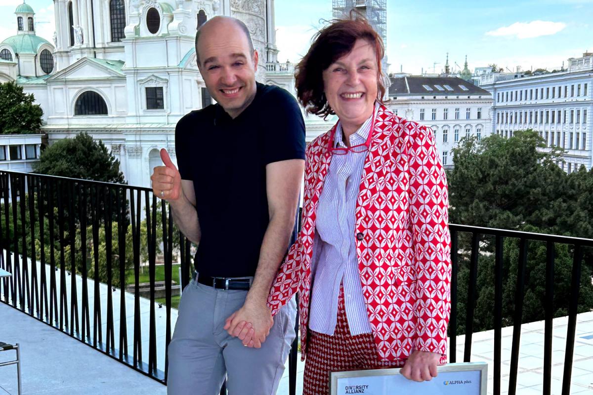 Mag. Sreco Dolanc und Mag. Karin Simonitsch stehen nebeneinander auf der Terrasse des Wien Museums und lachen herzlich. 