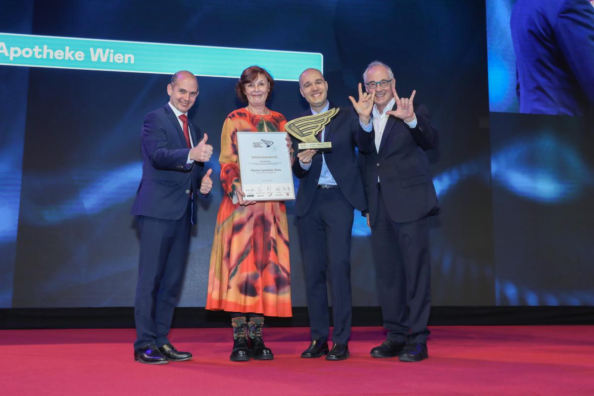 Karin Simonitsch und Sreco Dolanc stehen auf einer Bühne in der Hofburg. Von Martin Essl wurde ihnen der Austrian LEading Companies Award aus der Kategorie Inklusion verliehen