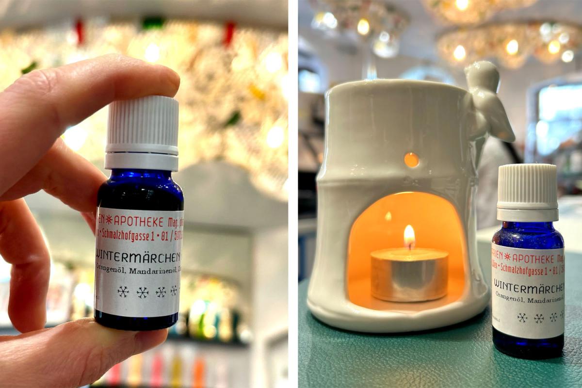 Wintermärchen-Duftöl und weiße Keramiklampe, in der ein Teelicht brennt. Im Hintergrund sieht man die Marien Apotheke Wien.