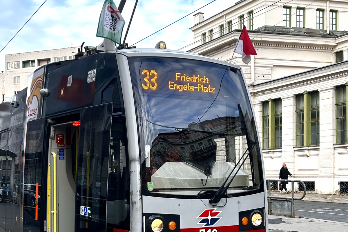 Eine Straßenbahn der Linie 33 mit Flagge der Aids Hilfe Wien. Die Marien Apotheke Wien ist Patin der Linie